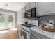 Galley kitchen features gray cabinets, stainless steel appliances, and access to the backyard at 261 Silver Ridge Dr, Dallas, GA 30157