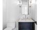 Compact half bathroom offers a stylish vanity with marble countertop and modern lighting fixtures at 325 Valley Brook Way, Atlanta, GA 30342