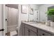 Bathroom featuring neutral colored tile tub and gray cabinets at 4824 Sultana Sw Way, Atlanta, GA 30331
