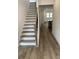 Staircase with wood railing and carpeted steps leading to the upper level, bathed in natural light at 76 Mayhaw Pt, Sharpsburg, GA 30277