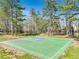Community basketball court surrounded by mature trees provides recreational opportunities at 8450 Sundial Ct, Johns Creek, GA 30024