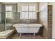 Bright bathroom featuring a standalone tub, tiled walls, and a glass-enclosed shower at 8450 Sundial Ct, Johns Creek, GA 30024