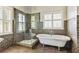 Elegant bathroom with a standalone tub, walk-in shower, and plantation shutters at 8450 Sundial Ct, Johns Creek, GA 30024