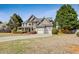 Charming two-story home featuring stone accents, a two-car garage and a lawn at 8450 Sundial Ct, Johns Creek, GA 30024