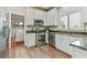 Charming kitchen featuring white cabinets, granite countertops, and stainless steel appliances at 8450 Sundial Ct, Johns Creek, GA 30024