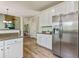 Open kitchen design with stainless steel refrigerator and granite counters adjacent to living room at 8450 Sundial Ct, Johns Creek, GA 30024