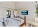 Comfortable main bedroom with tv over bed, access to bathroom, and neutral paint at 8450 Sundial Ct, Johns Creek, GA 30024
