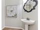 Elegant powder room with pedestal sink, decorative mirror and accent art at 8450 Sundial Ct, Johns Creek, GA 30024