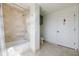 Bright bathroom featuring tiled walls, bathtub, shower, and a white door at 195 14Th Ne St # Ph206, Atlanta, GA 30309