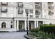 Elegant building exterior featuring black wrought iron balconies, manicured landscaping, and covered entryway with white pillars at 195 14Th Ne St # Ph206, Atlanta, GA 30309
