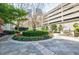 Serene courtyard with a stone-paved area, lush greenery, and an outdoor grill at 195 14Th Ne St # Ph206, Atlanta, GA 30309