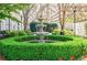 Beautiful courtyard featuring a multi-tiered fountain, manicured hedges, and floral accents at 195 14Th Ne St # Ph206, Atlanta, GA 30309