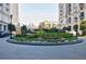 Circular driveway featuring a lush garden island with colorful flowers and greenery at 195 14Th Ne St # Ph206, Atlanta, GA 30309