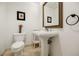 Bright powder room features a pedestal sink, framed mirror, and decorative accents, offering a touch of elegance at 195 14Th Ne St # Ph206, Atlanta, GA 30309