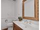 Well-lit powder room with a wooden vanity, a framed mirror, and a decorative houseplant at 1674 Executive Park Ne Ln, Atlanta, GA 30329