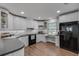 Well-lit kitchen featuring white cabinetry, black appliances and wood flooring at 1674 Executive Park Ne Ln, Atlanta, GA 30329