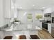 Bright kitchen featuring white cabinets, granite countertops, stainless steel appliances, and a breakfast bar at 2519 Miriam Ln, Decatur, GA 30032
