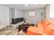 Finished basement features a painted brick fireplace, tiled floors and bright orange sofa at 3348 Lynnray Dr, Atlanta, GA 30340