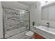 Modern bathroom with textured white tile and a marble-look tiled shower and glass door at 3348 Lynnray Dr, Atlanta, GA 30340