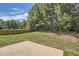 A spacious backyard features a concrete patio, lush lawn, and tall trees along the perimeter at 349 Pennant Ln, Fairburn, GA 30213
