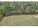 Large backyard features lush green grass, trees, and a wooden fence along the property line at 349 Pennant Ln, Fairburn, GA 30213