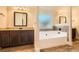 Well-lit bathroom with dark wood vanity, soaking tub, and tile flooring at 349 Pennant Ln, Fairburn, GA 30213