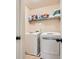 Modern laundry room with side-by-side washer and dryer with storage shelves at 349 Pennant Ln, Fairburn, GA 30213