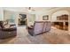 Open-concept living room with fireplace, large windows, carpet and easy access to the kitchen at 349 Pennant Ln, Fairburn, GA 30213