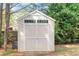 Backyard shed for extra storage, with windows and double doors, in a landscaped yard at 20 Saddle Wood Dr, Dallas, GA 30157