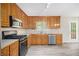 Kitchen featuring wood cabinets, stainless steel appliances, and luxury vinyl flooring at 314 Sable Trace Pass, Acworth, GA 30102