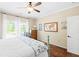 Bedroom featuring wood floors, fan, and two windows with white drapes for natural light at 3541 Haddon Hall Dr, Buford, GA 30519