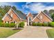 Charming brick home with lush landscaping, black shutters, and a well-manicured lawn at 3541 Haddon Hall Dr, Buford, GA 30519