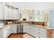Well-lit kitchen with white cabinets, granite countertops, stainless steel appliances, and views into the living area at 3541 Haddon Hall Dr, Buford, GA 30519