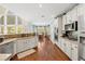 Well-lit kitchen with white cabinets, granite countertops, stainless steel appliances, and views into the dining area at 3541 Haddon Hall Dr, Buford, GA 30519