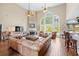 Soaring living room with stone fireplace, hardwood floors, large windows, and stylish leather furniture at 3541 Haddon Hall Dr, Buford, GA 30519