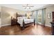 Well-lit main bedroom with hardwood floors, featuring a king bed, side tables, and natural light at 3541 Haddon Hall Dr, Buford, GA 30519