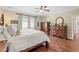 Well-lit main bedroom with hardwood floors and a ceiling fan, featuring a king bed and dresser at 3541 Haddon Hall Dr, Buford, GA 30519
