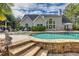 Large backyard pool with stone steps, in-water seating, and a backdrop of mature trees at 3541 Haddon Hall Dr, Buford, GA 30519