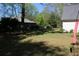 Fenced backyard view of a large grassy lawn with an outbuilding behind the main house at 4314 Saddlecreek Ct, Auburn, GA 30011