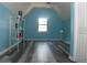 Bedroom with angled ceiling, gray wood-look flooring, light blue walls, and a storage shelf at 4314 Saddlecreek Ct, Auburn, GA 30011