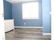 A bedroom with blue walls, grey flooring, and a white dresser by the window at 4314 Saddlecreek Ct, Auburn, GA 30011