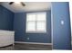 Bedroom featuring blue walls, grey flooring and a white dresser by the window at 4314 Saddlecreek Ct, Auburn, GA 30011