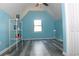 Bedroom with angled ceiling, gray wood-look flooring, light blue walls, and a storage shelf at 4314 Saddlecreek Ct, Auburn, GA 30011