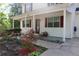 Inviting front porch with red door and shutters, surrounded by lush landscaping and a paved walkway at 4314 Saddlecreek Ct, Auburn, GA 30011