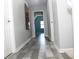 Hallway with gray walls, white trim, and stylish gray wood-look floors; bedroom visible at the end at 4314 Saddlecreek Ct, Auburn, GA 30011