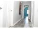 Hallway with gray walls, white trim, and stylish gray wood-look floors; bedroom visible at the end at 4314 Saddlecreek Ct, Auburn, GA 30011