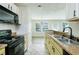 Bright kitchen with stainless steel sink, breakfast bar, and view into a well-lit dining area at 809 Brickleridge Se Ln, Mableton, GA 30126
