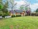 Charming home with manicured lawn, mature trees, and bright yellow painted siding at 2129 Fairhaven Ne Cir, Atlanta, GA 30305