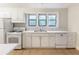 Bright kitchen with white cabinets, white appliances, and a window over the sink area at 2129 Fairhaven Ne Cir, Atlanta, GA 30305