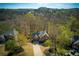 An aerial shot highlights the brick house's pristine lawn, set amidst a lush, wooded landscape at 2275 Barrett Dr, Cumming, GA 30040